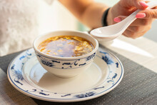 Woman Is Eating With Ceramic Spoon Chinese Vegetable Soup At The Restaurant