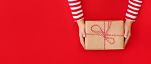 Banner Gift Box In Children's Hands On A Red Background, Presenting A Gift	
