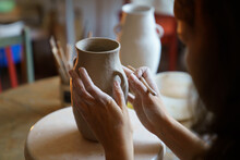 Creating Potter Tableware: Cropped Image Of Female Ceramics Artist Molding Clay Jug In Studio. Young Woman Learning Pottery Art During Master Class In Workshop. Self-employed Artist At Work Concept