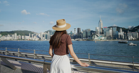 Wall Mural - Woman look at the Victoria harbor in Hong Kong