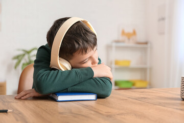 Sticker - Little boy with book and headphones sleeping at table