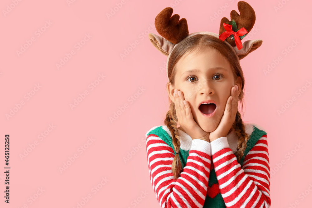 Surprised little girl dressed as elf on pink background