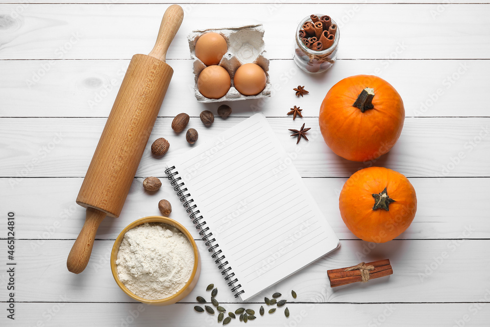 Ingredients for preparing pumpkin pie and notebook on light wooden background