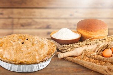 Canvas Print - Homemade round cake on the desk with ingredients: eggs, flour, milk