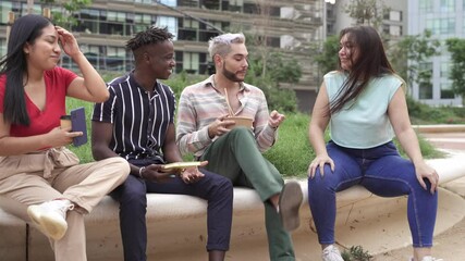 Wall Mural - Group of young multi ethnic colleague friends enjoying conversation while eating take out street food meal in the city park