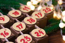 Handmade Advent Calendar With Yellow Garland. Christmas Preparations With Gifts And Assignments. Selective Focus.