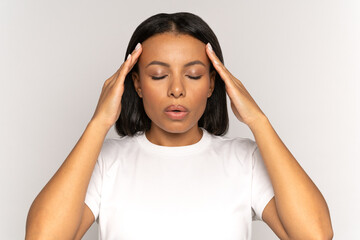 stressed young woman massaging temples and breathing in deeply to relief from emotional stress, anxi