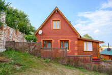 Red Brick Rustic House Behind A Wooden Fence On A Hillside In The Village Of Sviyazhsk, Russia