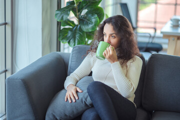 Lifestyle relaxes. Latin woman relaxing at home with a cup of hot tea or coffee.