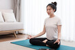 © snowing12 - Productive activity concept a calm girl concentrating on meditating alone among peaceful atmosphere in the living room