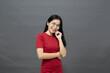© 1981 Rustic Studio - Asian woman brunette in a red dress cross arms
