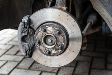 Wall Mural - Front assembly of ventilated disc brake and wheel hub on an used car, view with removed wheel.