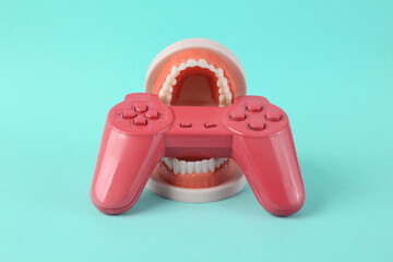 Wall Mural - Joystick in the teeth of the jaw model. Minimal creative gaming concept