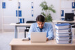 © Elnur - Young male employee and too much work in the office
