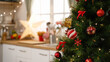© PRPicturesProduction - kitchen at Christmas time in bright modern home interior. focus view on xmas tree in side with blurred back view of cooking place in apartment. red and gold balls decorations hanging on tree
