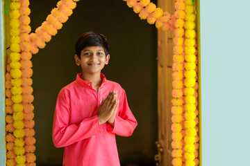 Cute indian little boy praying and celebrating diwali festival.