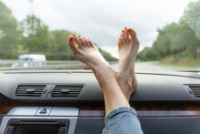 Mature Woman With Feet Up On Car Dashboard