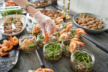 Wall Mural - The waiter sets the table. Delicious fresh seafood, shrimp with fresh vegetables. buffet table with lots of delicious snacks.