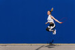 © Westend61 - Female athlete jumping rope in front of blue wall