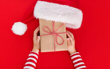 Gift Box In Children's Hands On A Red Background, Presenting A Gift, Christmas Background