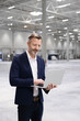 © Westend61 - Businessman using laptop while standing in industry