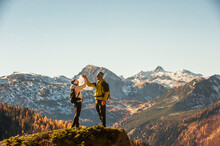 Two Hikers High-fiving On Top Of Edge InEnnstal Alps