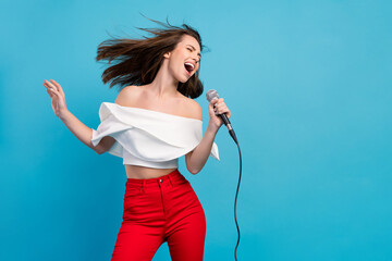 Canvas Print - Photo of joyful happy positive woman sing karaoke wind blow hair star celebrity isolated on blue color background