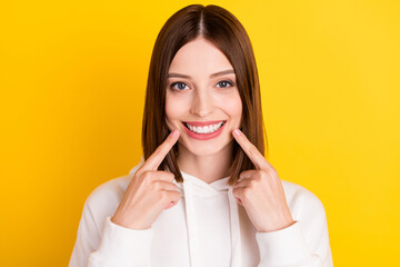Wall Mural - Photo of candid lady direct fingers healthy teeth implants wear white hoodie isolated yellow color background