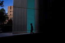 Silhouette Man Walking By Building In City