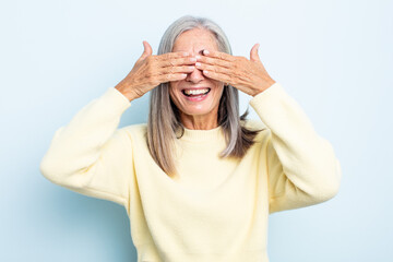 Wall Mural - middle age gray hair woman smiling and feeling happy, covering eyes with both hands and waiting for unbelievable surprise