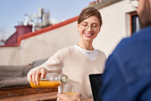 Smiling Woman Pouring Juice To Friend