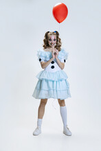 Close-up Portrait Of Charming Young Girl In Halloween Costume Of Movie Character With Spooky Facial Expression Isolated Over Blue Background