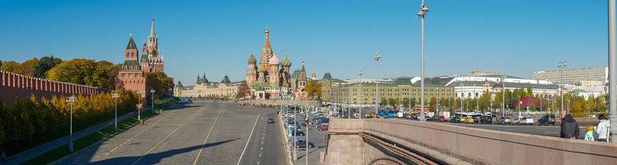 Moscow, Russia - October 5, 2021: Panoramic view of the Kremlin and St. Basil's Cathedral from the Moskvoretsky bridge. People walk in Red Square on a sunny day.