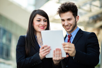 Wall Mural - Couple of business people using a tablet outdoor