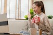 © KMPZZZ - Celebrate on Christmas, new year season, asian pretty young woman, girl greeting on video call during coronavirus, social distance and holding gift box, happy to get present on birthday, merry xmas.