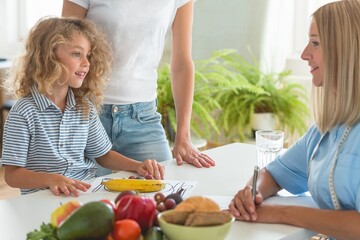 Canvas Print - Worried mother and little boy during a visit to a dietitian preparing a healthy diet plan