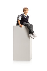 Sticker - Schoolboy in a uniform sitting on a white column and looking at camera