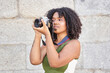 portrait of a young woman taking a photograph with a reflex camera