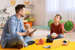 © Pixel-Shot - Male psychologist working with little boy in office. Autism concept