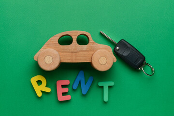 Poster - Wooden car with word RENT and key on green background