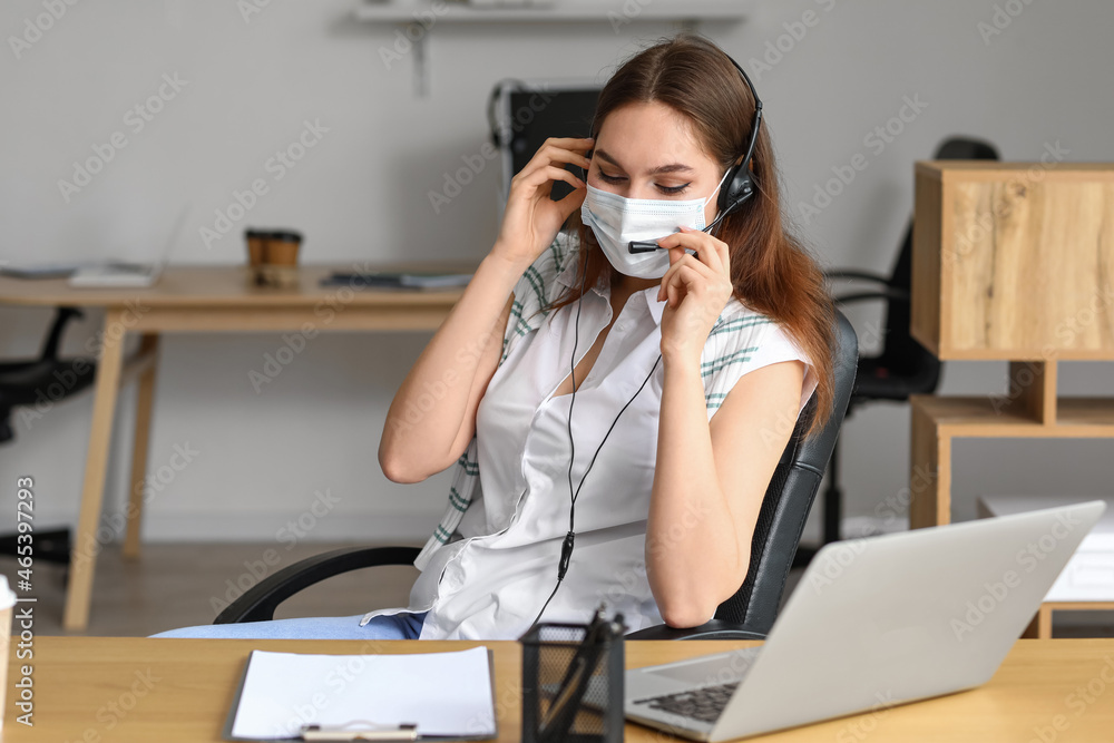 Technical support agent in medical mask working in office