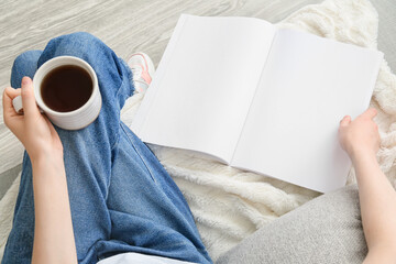 Canvas Print - Woman with blank magazine and cup of tea on light background