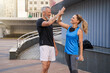 © Kostiantyn - Sportive middle aged friends, man and woman in sportswear giving high five, standing together outdoors ready for exercising