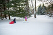 © Sarah Rypma - Young girl sledding outdoors on a snowy winter day during holiday