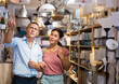 © JackF - Positive couple customers choosing ceiling lamp in modern household store