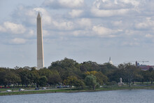 Washington, DC, USA - October 25, 2021: The Washington Monument And The Top Of The Rotunda Of The U.S. Capitol Peak Over The Tree Line As Seen From Across The Potomac River