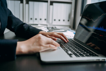 Canvas Print - Close up of Businesswomen or investor using laptop trading on the stock market, graph candlestick chart index screen, technical price indicator, investment and financial concept.