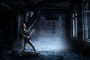 Wall Mural - Young and beautiful rock girl playing the electric guitar