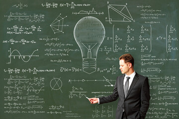 Wall Mural - Attractive young european male drawing abstract lamp sketch with mathematical formulas on chalkboard/blackboard wall background. Intelligence, idea, solution, science and innovation concept.