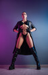 © rotozey - sexy woman in underwear, leather raincoat and long leather shoes in the studio on a neon background